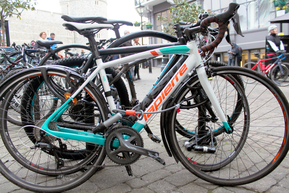 A Bicycle secured with a D-Lock and cable, securing both wheels and the cycle frame.